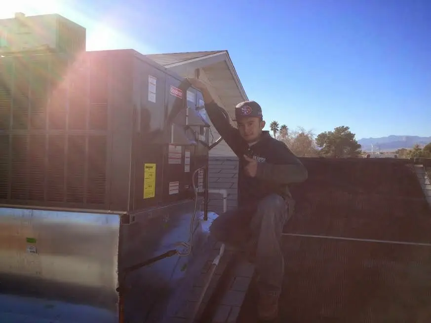HVAC technician performing AC Tune-Up on a rooftop unit in New Prague